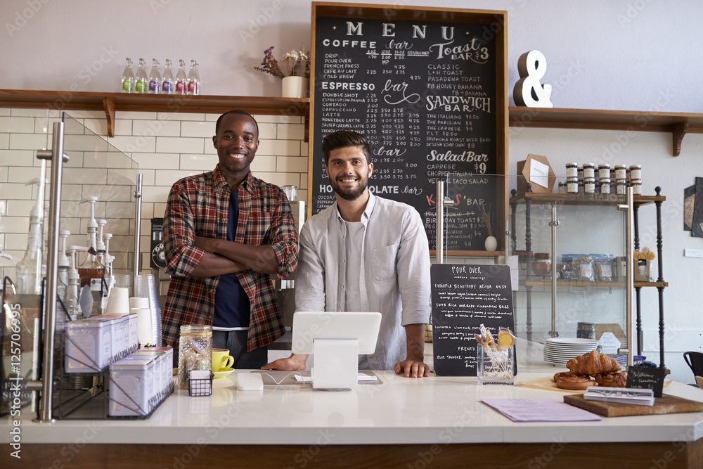 Business partners stand behind the counter at a coffee shop