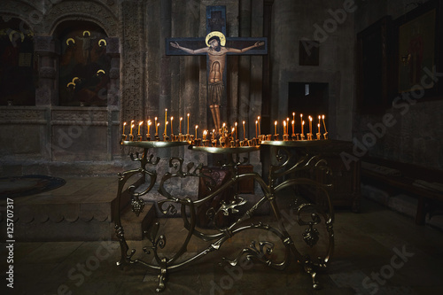 Foto Burning candles near cross with calvary in georgian Samtavro church