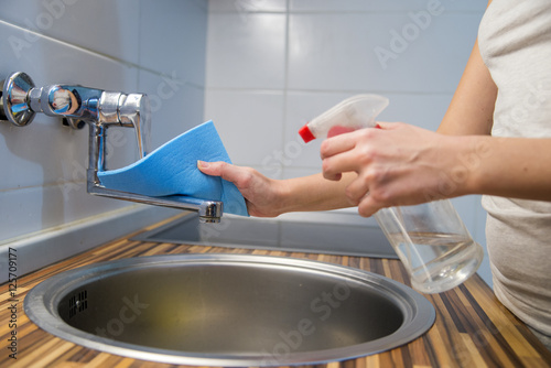  woman cleaning kitchen tops at home