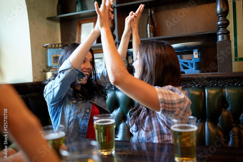 Sticker happy friends with beer celebrating at bar or pub