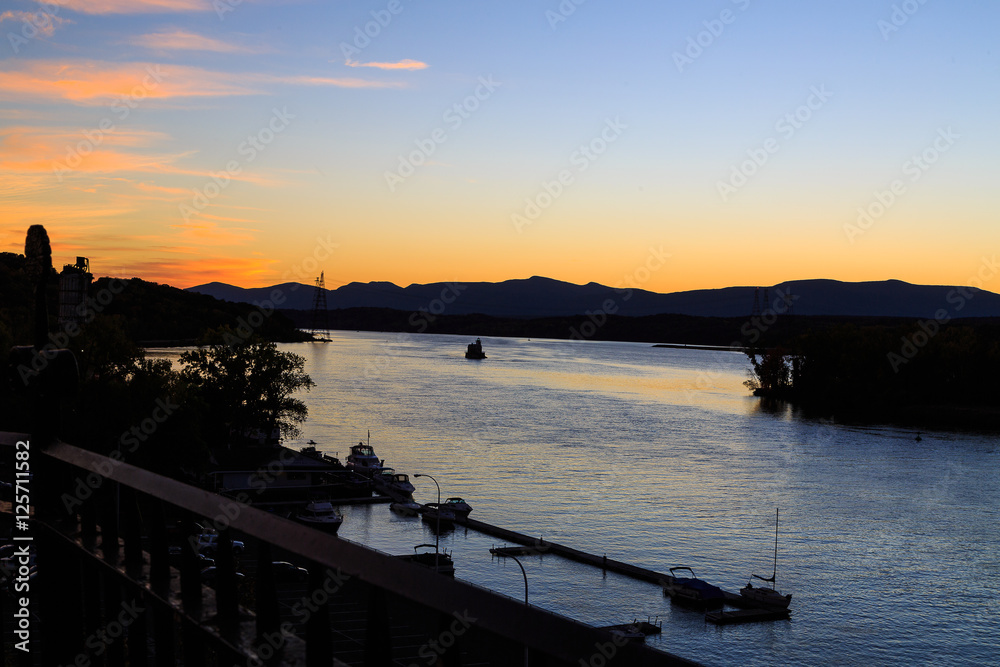 Fototapeta premium Hudson River at dusk in Hudson with lighthouse and boats