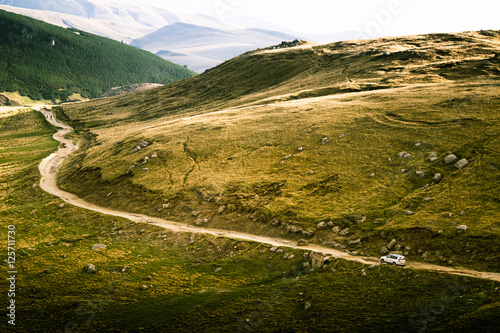 A beautiful Carpathian scenery with a road and a car