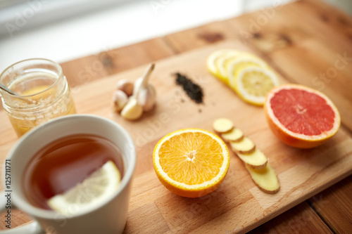 ginger tea with honey, citrus and garlic on wood