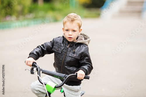 portrait of adorable little urban boy wearing black leather jack