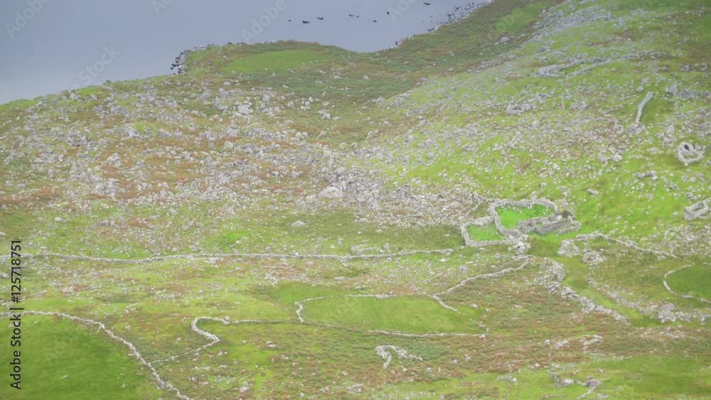 A small lake in the middle of the mountain steep with the green grasses and rocks that can be seen in Skyroad route in Ireland A small lake in the middle of the mountain steep with the green grasses and rocks that can be seen in Skyroad route in Ireland
