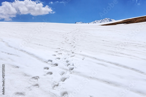 Vanishing human footprints on the snow in the winter mountains scenery