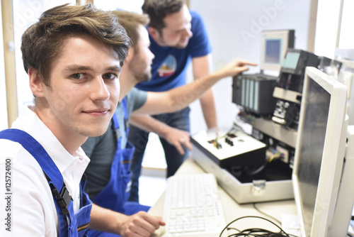 Portrait of smiling student with technical instructor in background photo