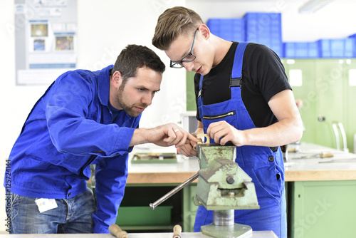 Instructor with trainee at workbench photo