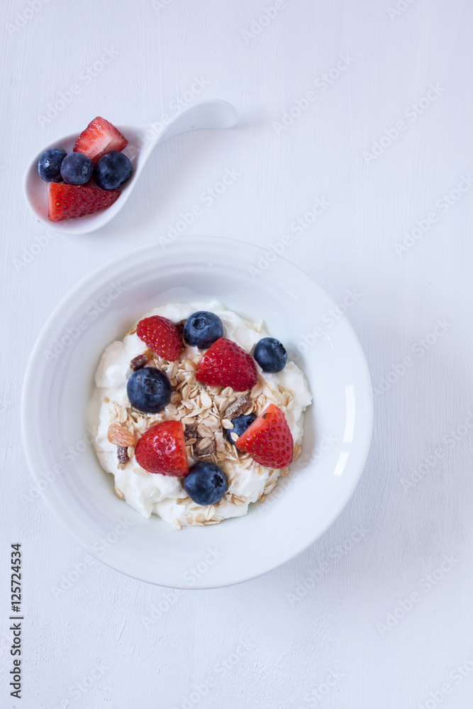 muesli with berries and yogurt on a white backgrund muesli with berries and yogurt on a white backgrund