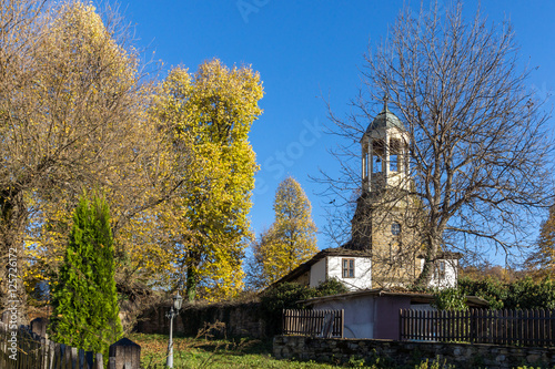 Autumn trees and Church of Saint Prophet Elijah in village of Bozhentsi, Gabrovo region, Bulgaria