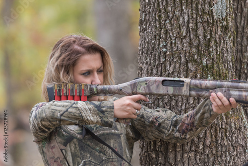 Obraz na plátne Woman hunting and aiming a shotgun