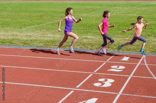Family sport, mother and kids running on stadium track, training and children fitness concept 