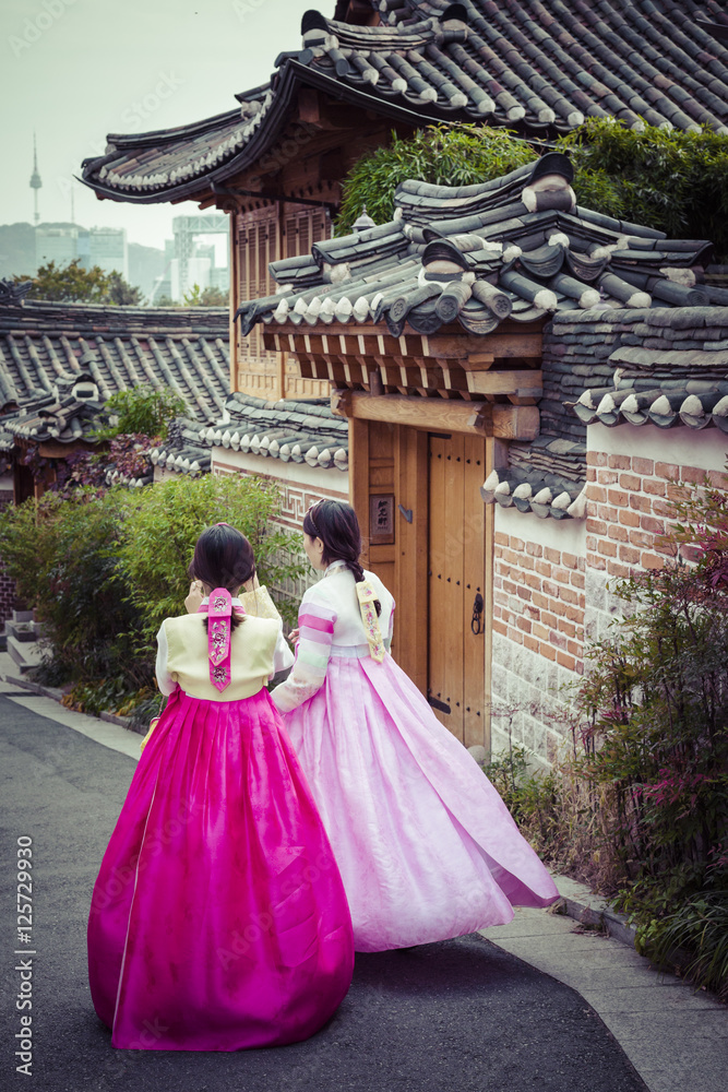 Fototapeta premium Kilka kobiet spaceruje po tradycyjnych domach w wiosce Bukchon Hanok w Seulu w Korei Południowej.