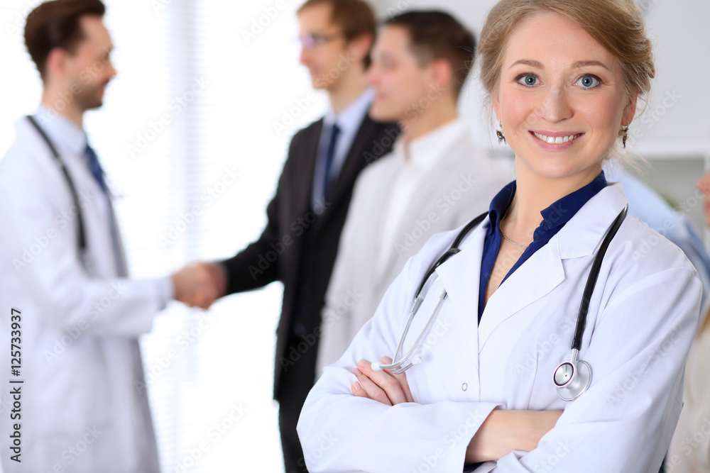 Happy doctor woman on the background doctor and many patients Happy doctor woman on the background doctor and many patients