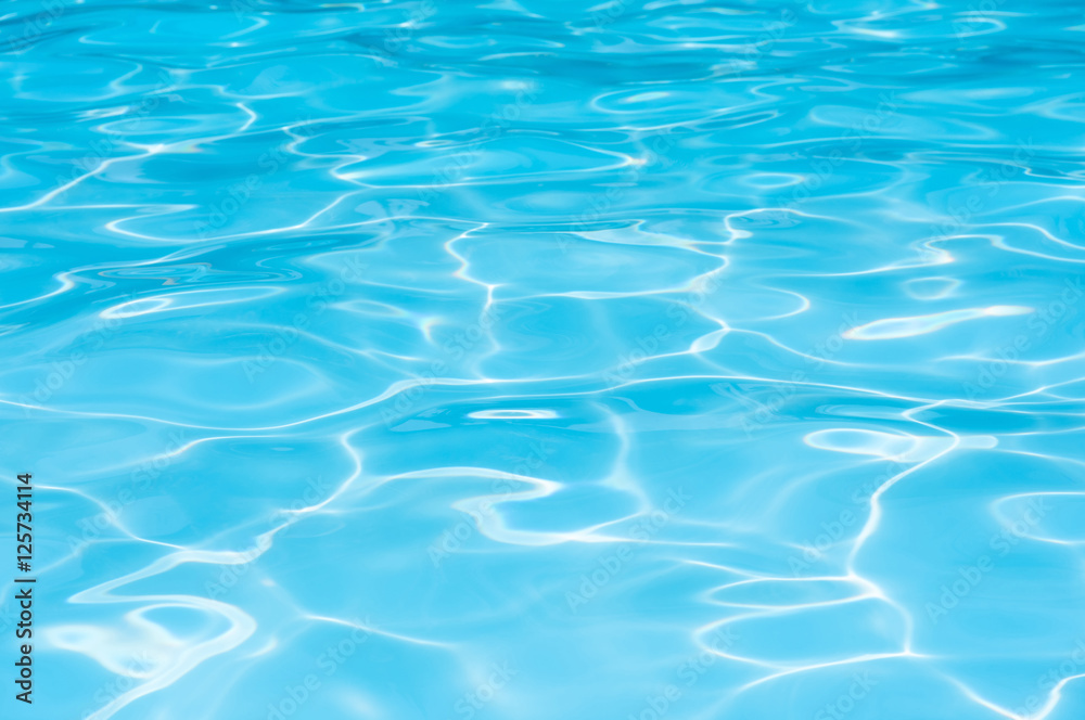 Blue water in swimming pool witn sun reflection