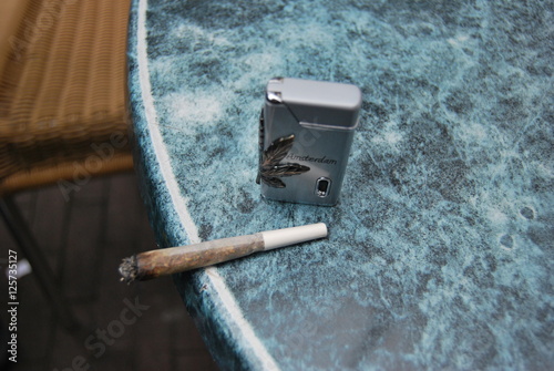 A joint of marijuana and a lighter with symbol of the drug