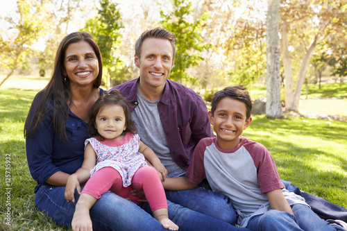 Happy Asian Caucasian mixed race family  portrait in a park