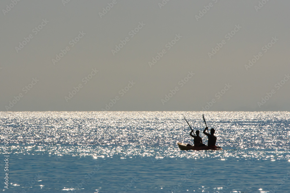 Fototapeta premium Silhouette of a couple on a boat in the sea at sunrise. Koh Rok island, Krabi, Thailand.