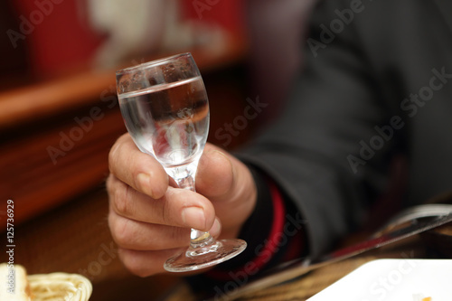 Person holding glass of vodka