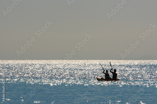 Silhouette of a couple on a boat in the sea at sunrise. Koh Rok island, Krabi, Thailand.