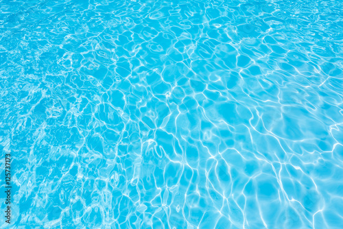 Ripple water in swimming pool with sun reflection