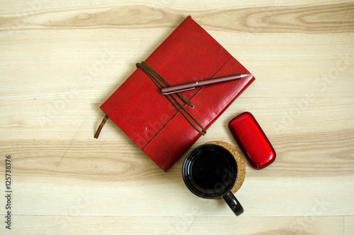 Set of cup, red daily planner and cellphone