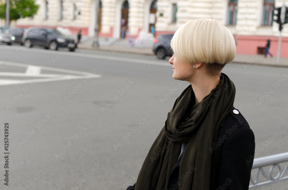 Young blonde woman walking in the city
