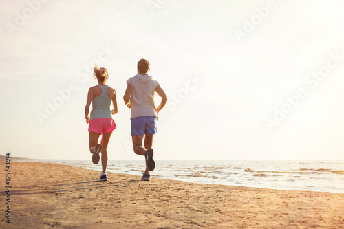 Two people running on the beach