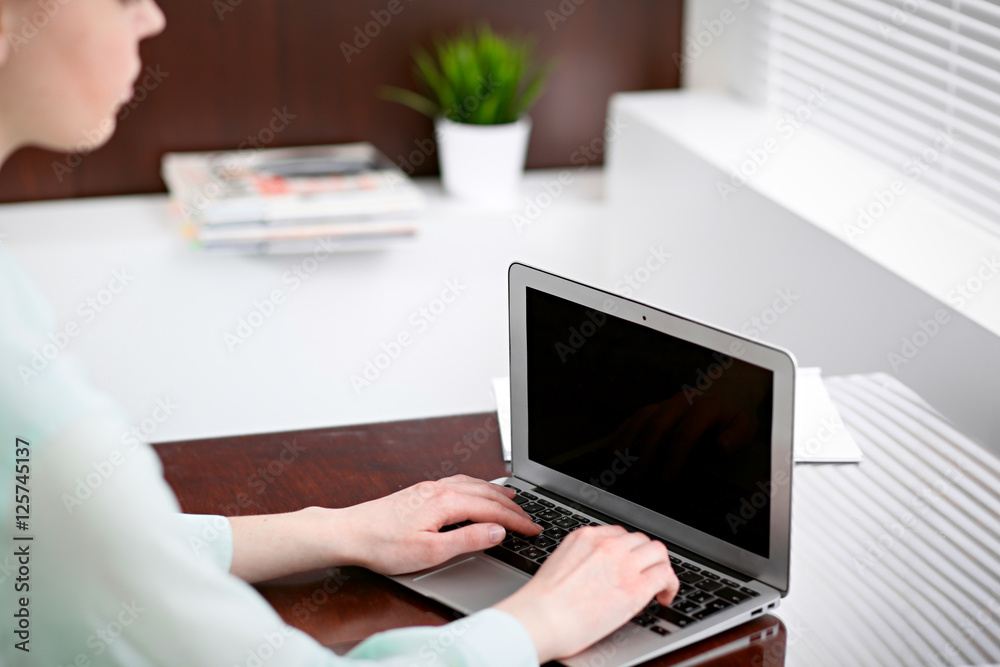 Business woman hands in a green blouse sitting at the desk in the office and typing on the laptop . Business woman hands in a green blouse sitting at the desk in the office and typing on the laptop .