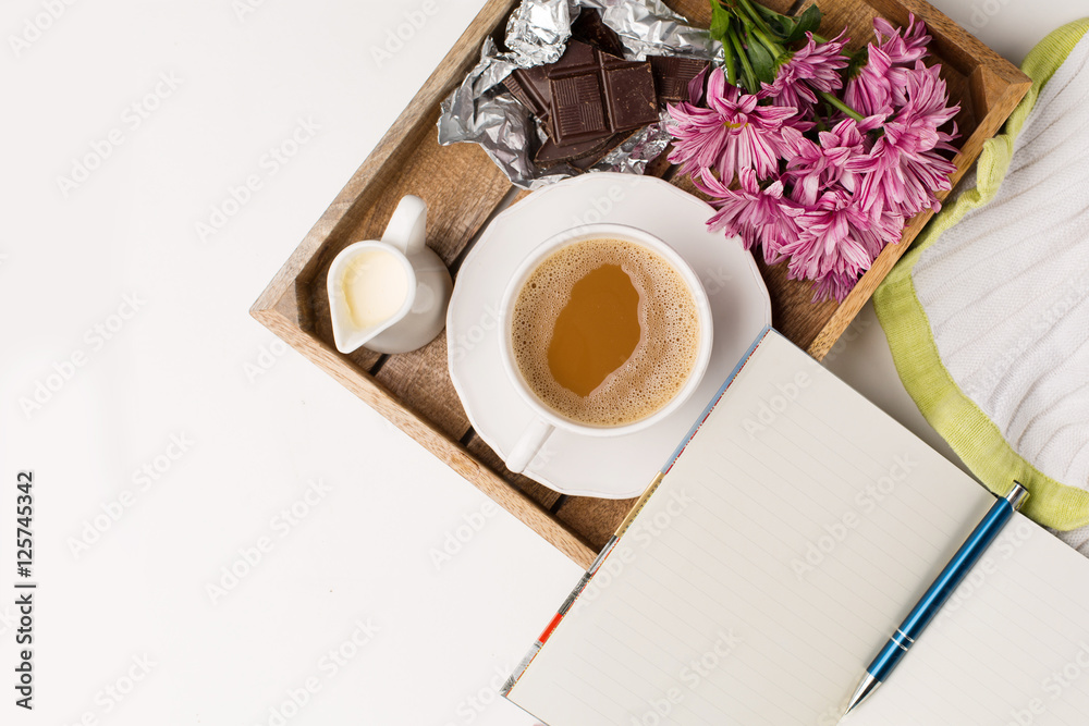 Cup of coffee, Bouquet of pink flowers, Chocolate and Empty paper notebook, top view Cup of coffee, Bouquet of pink flowers, Chocolate and Empty paper notebook, top view