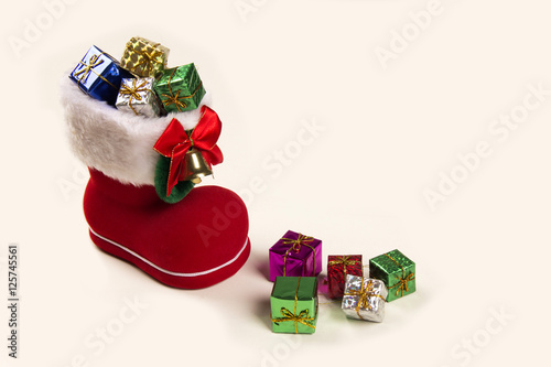 Red santa boot with christmas gifts on white background