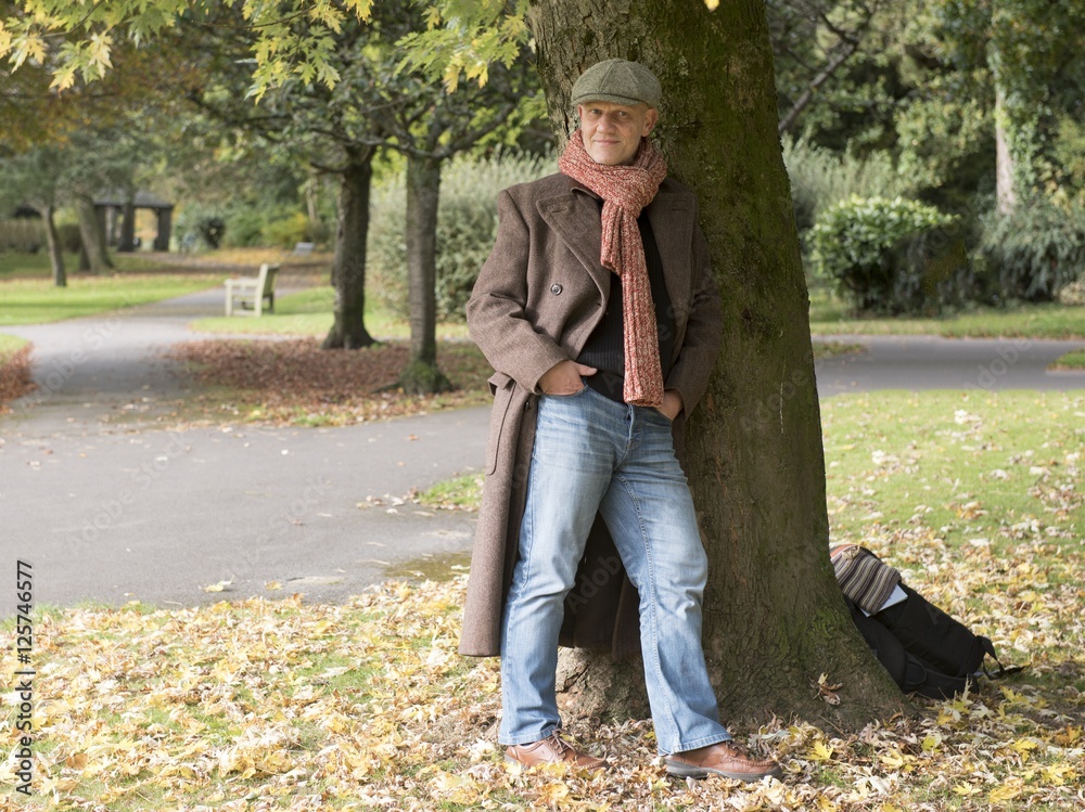 Fototapeta premium Portrait of a mature man standing under a tree outdoors. 