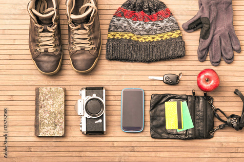 Winter season personal male belongings view from above - Essential clothing and objects for trekking excursion or short trip in cold days - Main focus on vintage camera © akhenatonimages