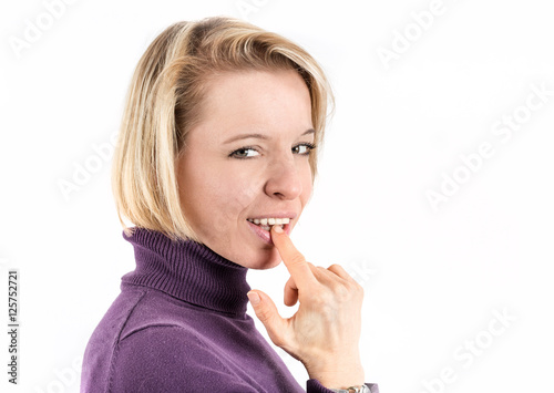 Photography Shot of a blonde woman putting her finger in her mouth in front of a white backg