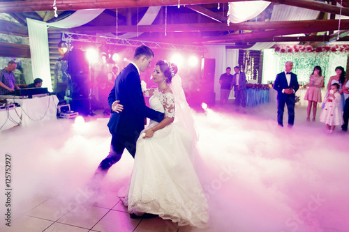 Bride and groom dance at the first time in white smoke