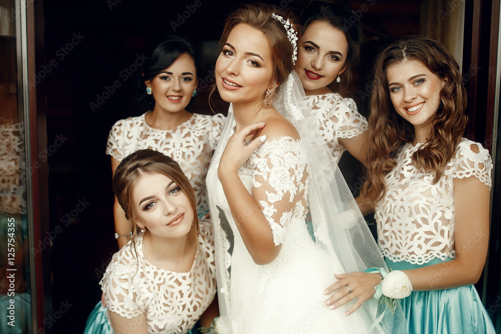 Obraz premium Bride holds her hand on the shoulder while bridesmaids hug her