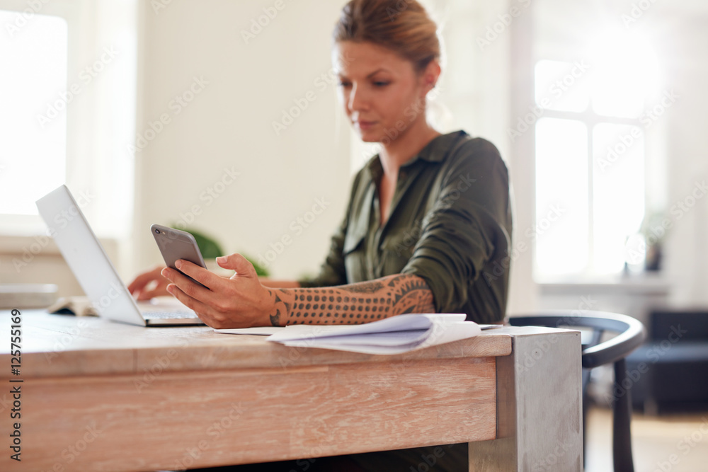 Woman at home office using mobile phone Woman at home office using mobile phone