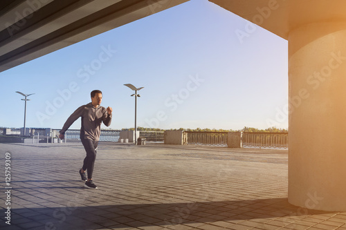Young fit man running at outdoors, autumn , attractive dark skinned runner jogging fast, sport concept