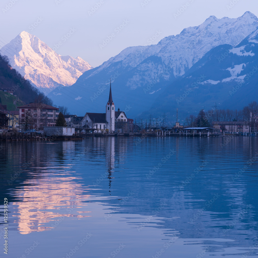 Switzerland. Alpine town of Fluelen. Snow-covered mountains in the light of the setting sun.