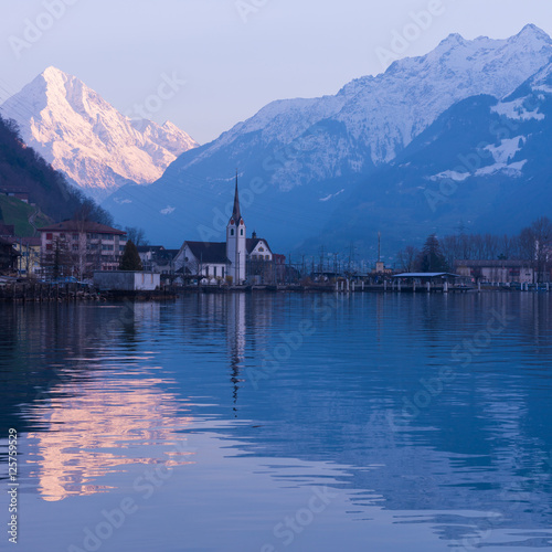 Switzerland. Alpine town of Fluelen. Snow-covered mountains in the light of the setting sun.