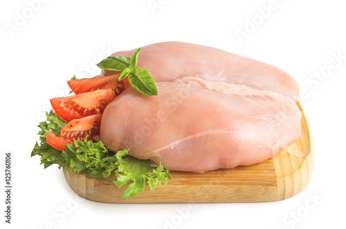 Chicken fillet with basil, tomato and lettuce on the board. On white, isolated background.