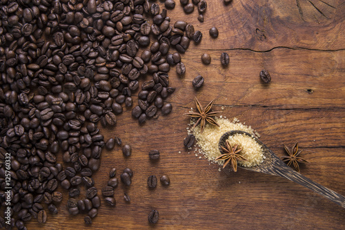 Coffee with brown sugar and anise on old wooden background.