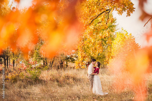 Stylish and romantic caucasian couple in the beautiful autumn park. Love, relationships, romance, happiness concept. Bouquet in girl's hands. © anna_gorbenko