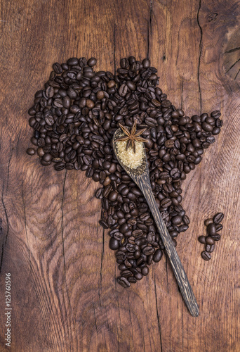 Roasted coffee beans arranged in the shape of Africa on old wood