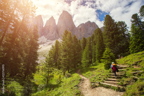 Group of Hikers walking on a mountain trail in vall di Funes, Dolomite Alps, Northern Italy