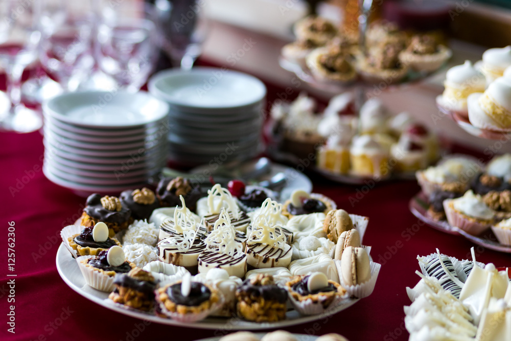 Naklejka premium Candy Bar. Delicious sweet buffet with cupcakes. Sweet holiday buffet with cupcakes and other desserts.Table with sweets, candies, dessert