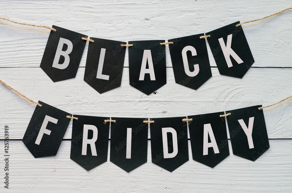 Fototapeta premium Black Friday paper banner garland lettering hanging on white barn wood planks background. Beautiful holiday flyer.