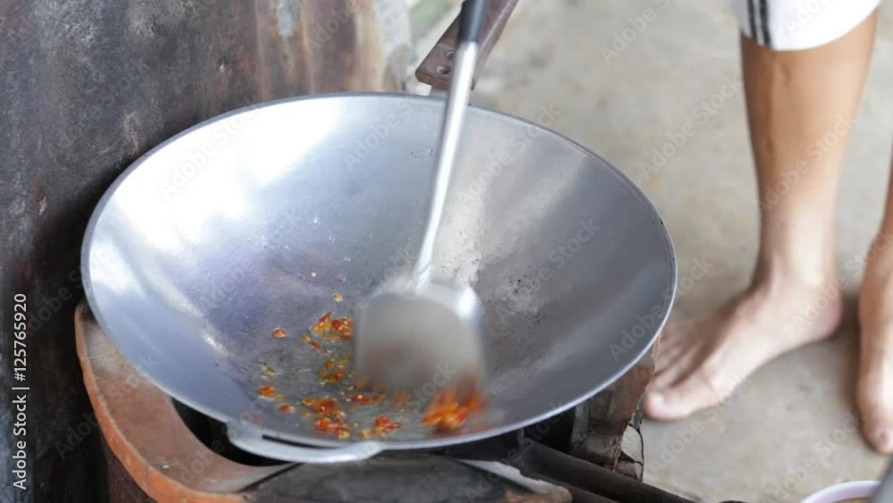 Cook is frying chili with vegetable oil Cook is frying chili with vegetable oil