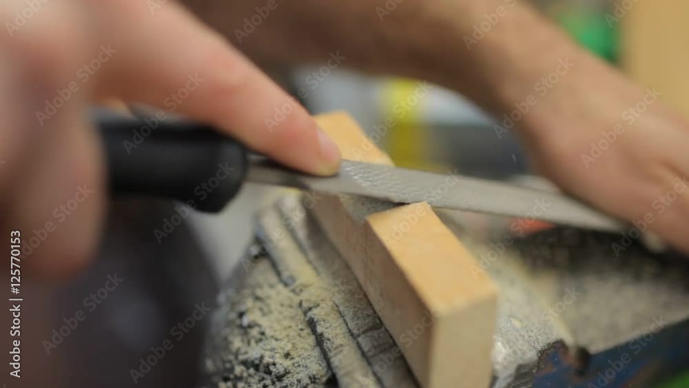 Close up on hand working with file on wood Close up on hand working with file on wood
