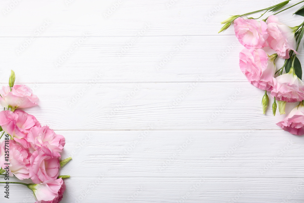 Fresh pink flowers frame on wooden background